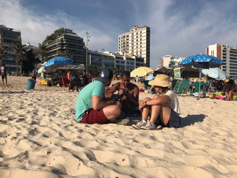 Carolina Walliter e Brandon Stanton entrevistando família brasileira na praia de Ipanema